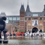 A group of people walking in front of Rijksmuseum